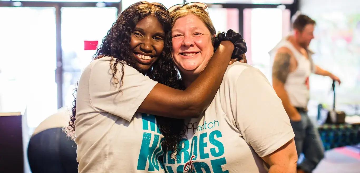 Two HOPEmatch volunteers sharing a hug.